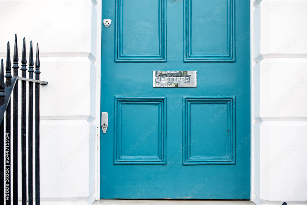 Beautiful blue door with letterbox in a white house facade in Notting Hill Beautiful blue door with letterbox in a white house facade in Notting Hill