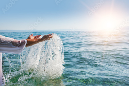 Woman hands splashing sea water. Holidays at the resort concept.