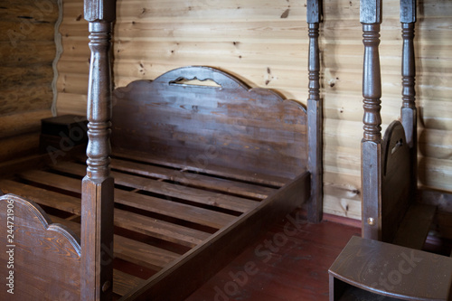 Wooden bed in the wooden bedroom photo