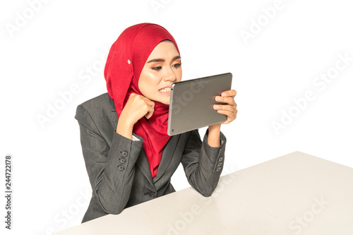Businesswoman looking her teeth via tab as a mirror. Candid concept.