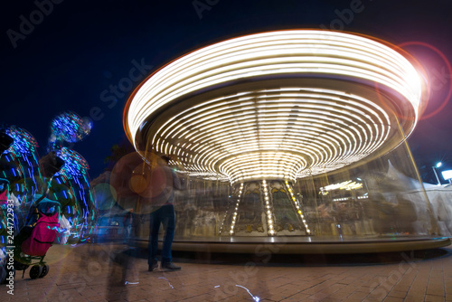 Abstract  long exposure shot of spinning Children s vintage Carousel at an amusement park in the evening and night illumination. Beautiful  bright carousel in Alicante  Spain  