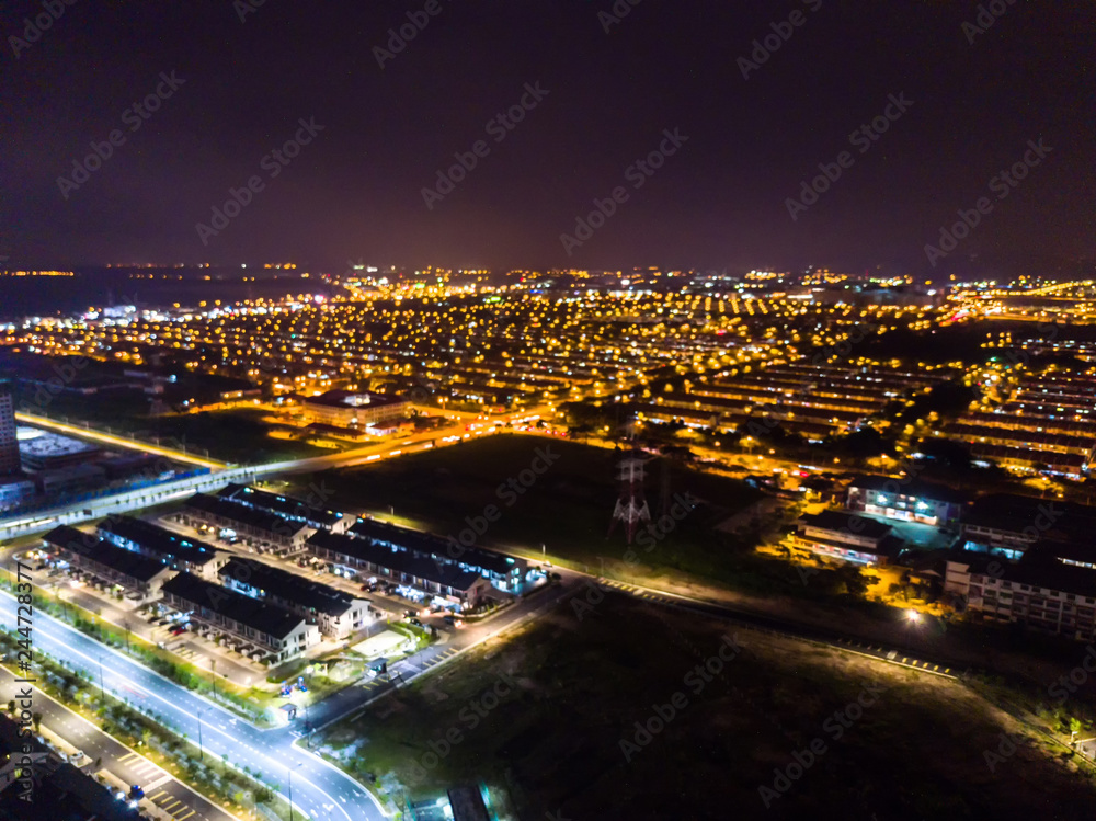 Aerial with blurred view of residential houses in night light.