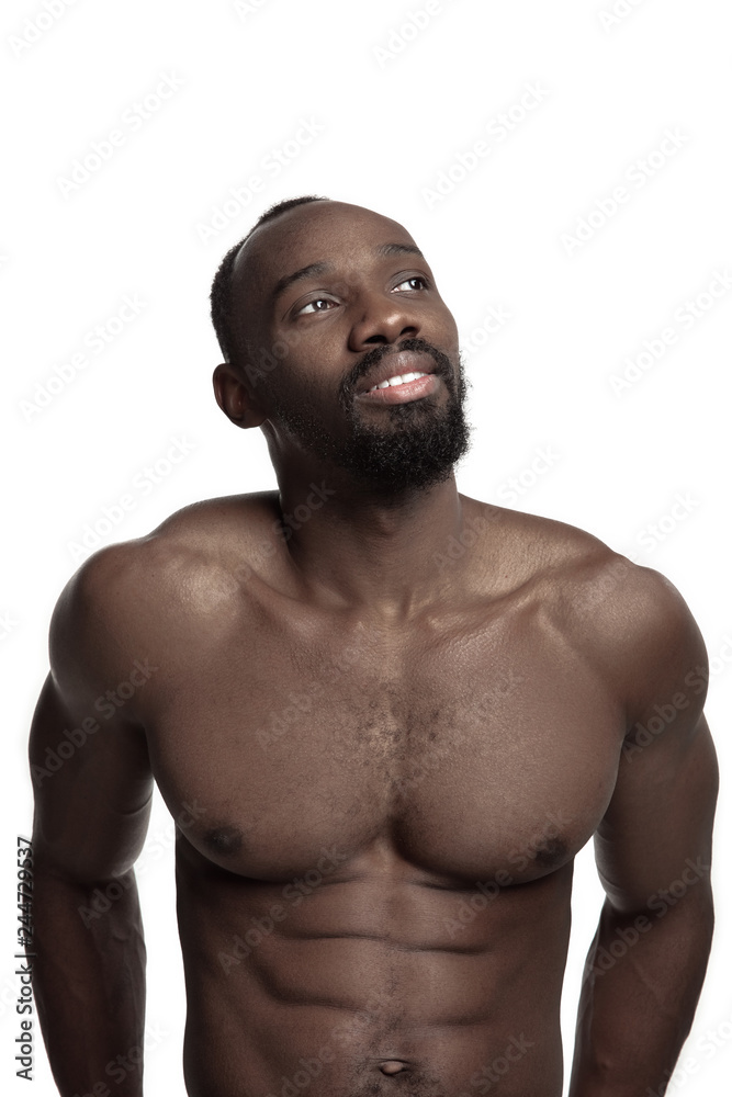 Portrait of a young naked happy smiling african man at studio. High Fashion male model posing and isolated on white background Portrait of a young naked happy smiling african man at studio. High Fashion male model posing and isolated on white background