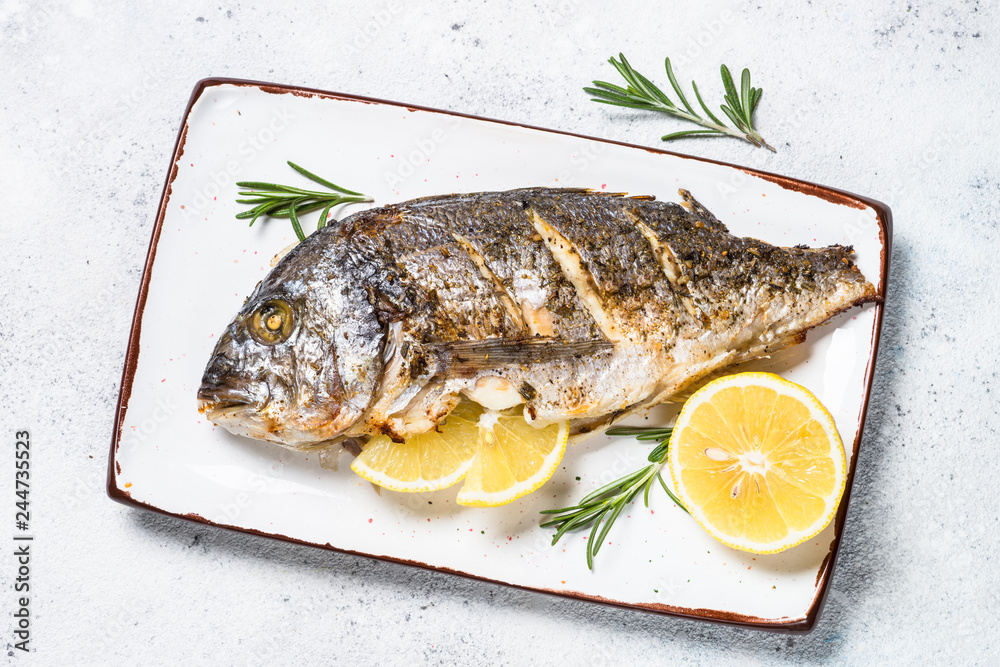 Baked dorado fish with lemon and rosemary top view. Baked dorado fish with lemon and rosemary top view.