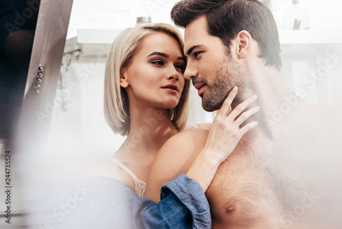 Принти на полотні selective focus of attractive girlfriend and handsome boyfriend hugging at kitch