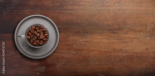 Coffee cup and beans on wooden background, copy space