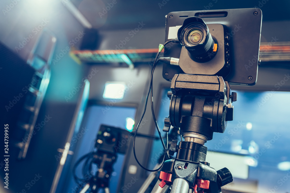 Modern film camera on a tripod in a broadcasting studio, spotlights and other equipment