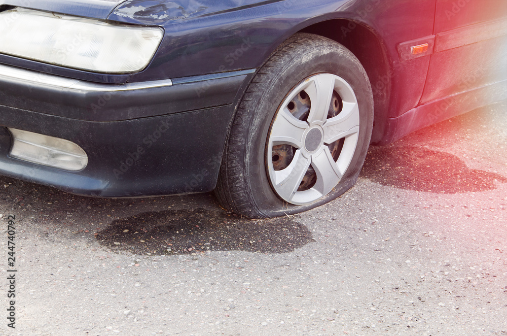 Close-up Of A Damaged Flat Tire Of A Car On The Road Close-up Of A Damaged Flat Tire Of A Car On The Road