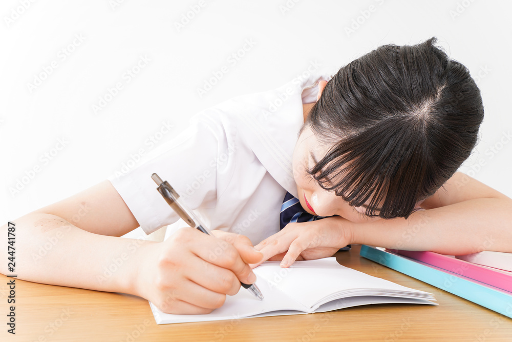 制服姿で勉強をする若い学生 制服姿で勉強をする若い学生