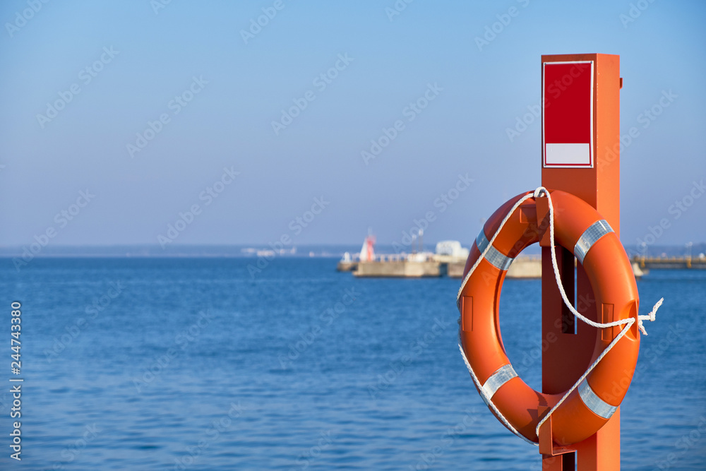 Orange lifebuoy by the sea