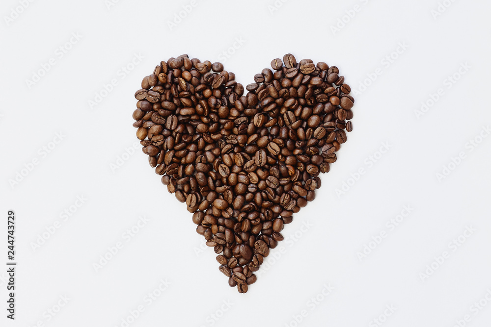 Roasted coffee beans in a shape of heart on white background. Mock up, top view Roasted coffee beans in a shape of heart on white background. Mock up, top view