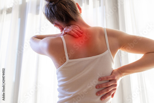 Photography Young woman suffering from neck pain and backache, stretching the muscles