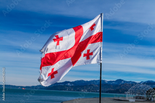 Photography Georgian flag waving in the wind on the background of blue, clear sky