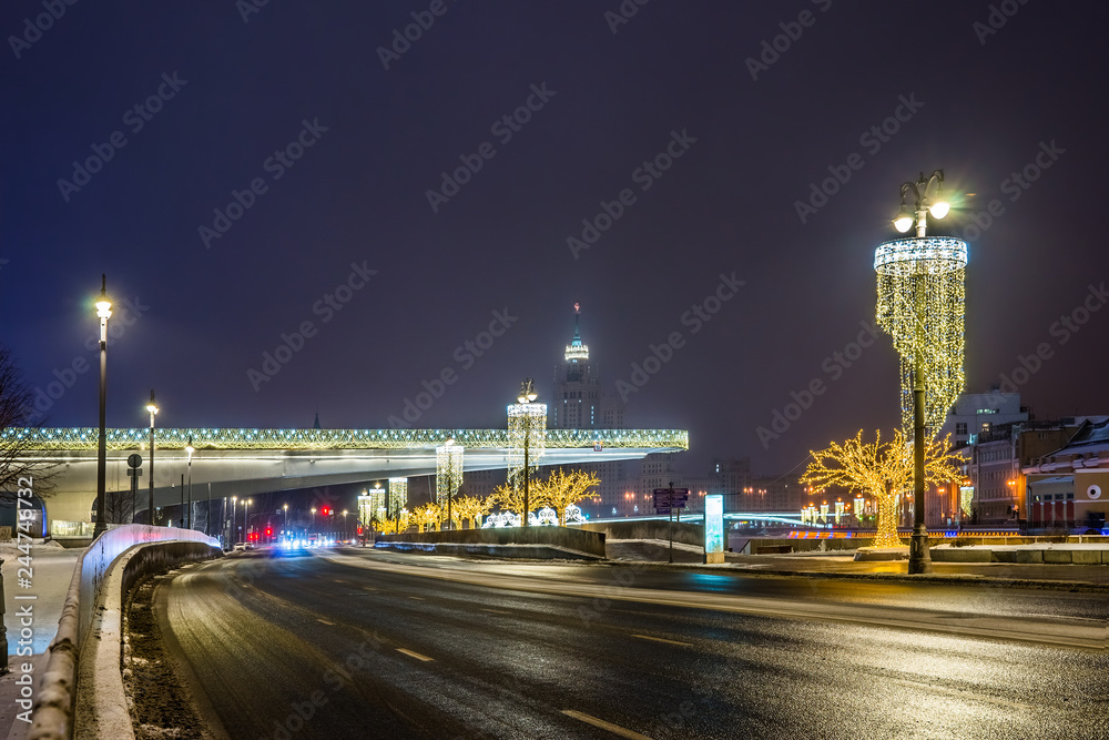 Moskvoretskaya embankment near Zaryadye Park with the illuminated floating bridge. Moscow, Russia.