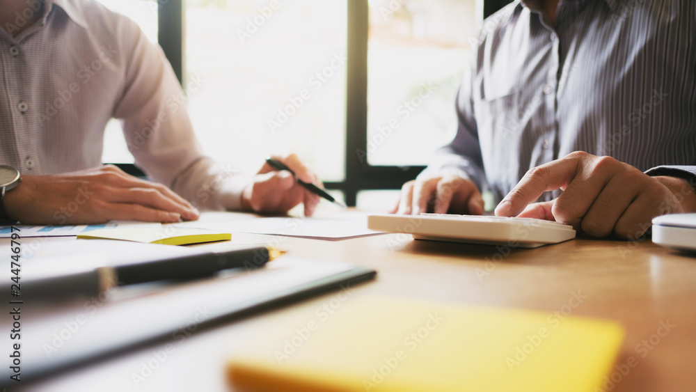 team of business collaboration working on spreadsheets calculating a value of stock market exchange. team of business collaboration working on spreadsheets calculating a value of stock market exchange.