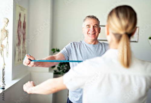 A Modern rehabilitation physiotherapy worker with senior client