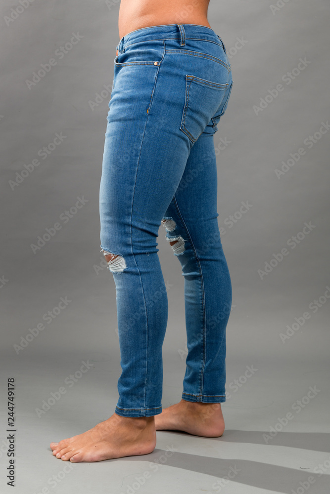Modern male unbranded Blue skinny ripped jeans isloated on grey background Modern male unbranded Blue skinny ripped jeans isloated on grey background