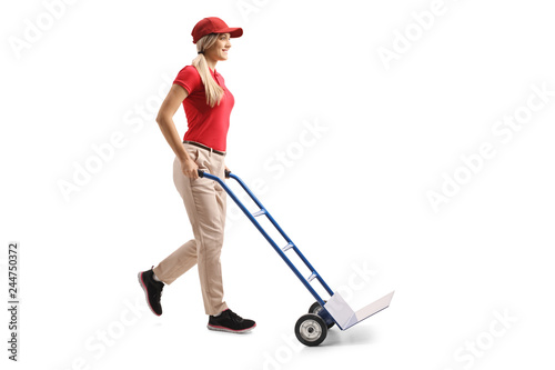 Young female worker pushing an empty hand truck