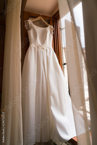 white wedding dress hanging on a hanger