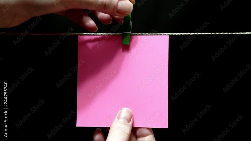 Copy space. Pure pink sticker. The sheet is manually attached with a clothespin on the rope.