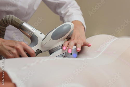 Lymphatic drainage massage LPG apparatus process. Woman in white suit getting anti cellulite massage in a beauty SPA salon. Contouring treatment in clinic. Massage procedure on female body. Body care.