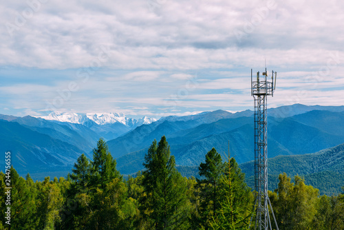 Telecommunication cell tower in the wild forest with mountain background, Altay photo