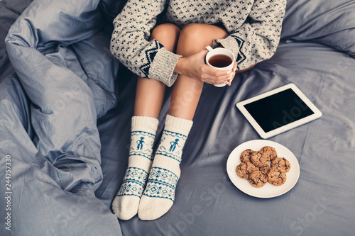 Young woman enjoying cozy time with tablet in bed photo