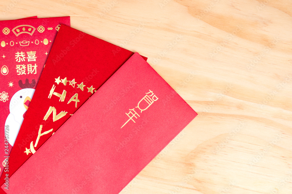 Red envelope packet chinese new year, hongbao with the character 'Happy New Year' on wood background for Chinese New Year. Translation: Good luck in the year Red envelope packet chinese new year, hongbao with the character 'Happy New Year' on wood background for Chinese New Year. Translation: Good luck in the year