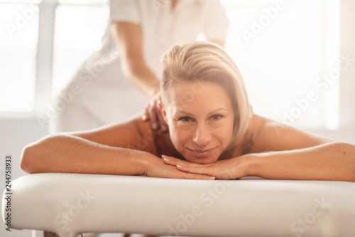 A Woman enjoying spa treatment at salon with masseur worker