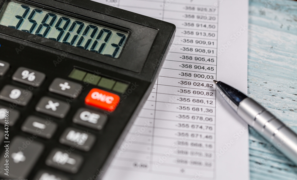 Calculator with digits lie on financial document and pen are on the desk Calculator with digits lie on financial document and pen are on the desk