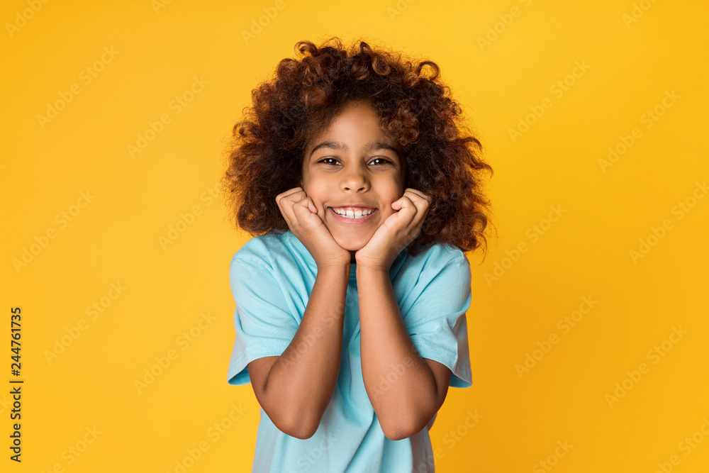 Cute african-american girl posing and looking at camera Cute african-american girl posing and looking at camera