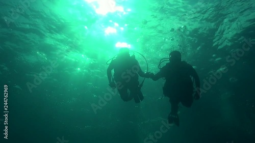 Divers silhouette against sun ball photo