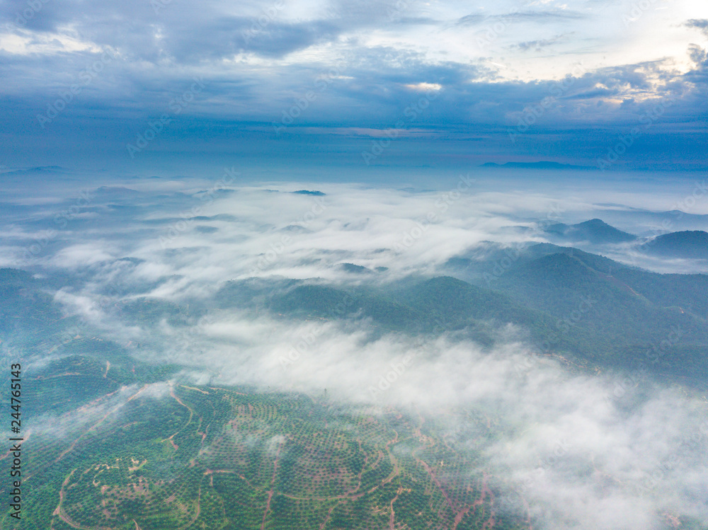 Aerial view of mountain and morning mist during sunrise.