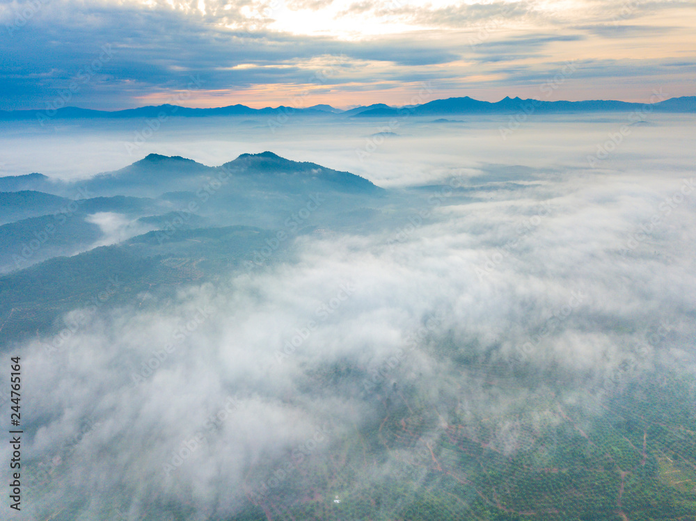 Aerial view of mountain and morning mist during sunrise.