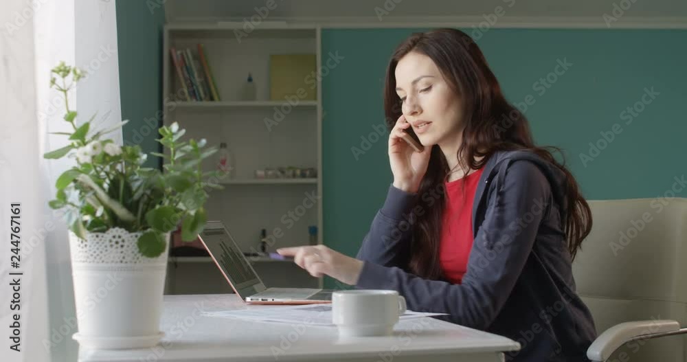 Attractive Brunette Woman Freelancer Working from Home Computer and Talking on the Phone Rejoicing Success with Sales