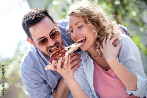 Tourist happy couple sharing pizza