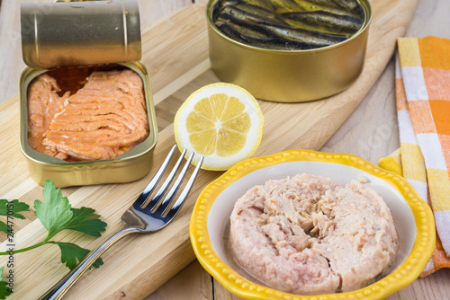 Varieties of open canned fish. Smocked salmon filets, sprats and bowl with tuna. photo