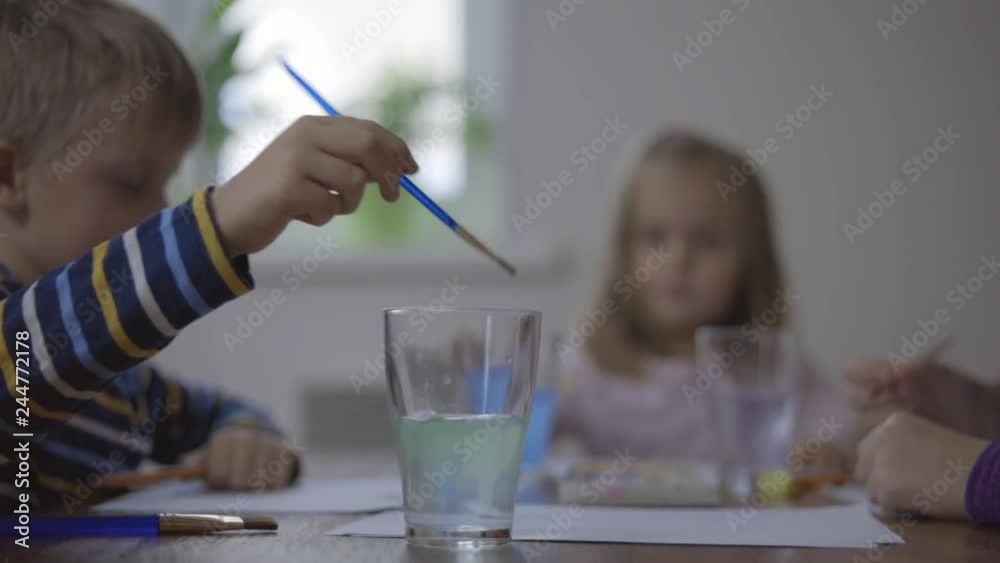 Brother and two sister are drawing with paint. Brother and two sister are drawing with paint.