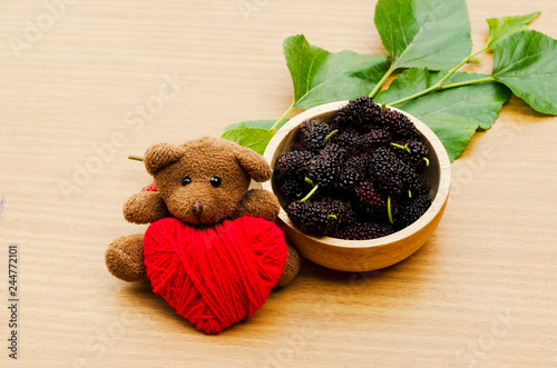 Close up of Teddy dol with red heart and Mulberry fruits photo