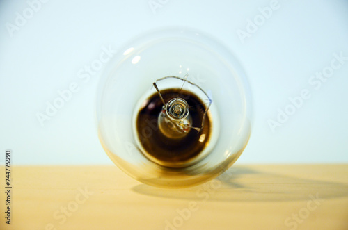 Incandescent lamp on a wood and glass background