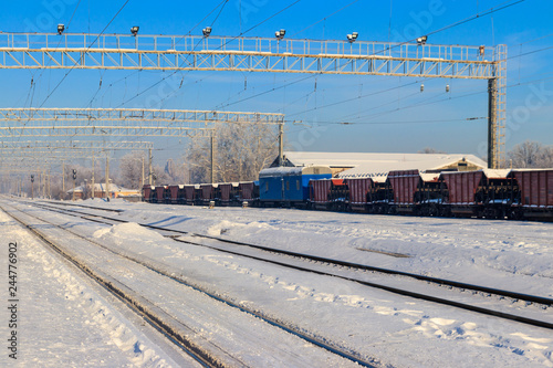 Snowy railroad tracks at the station on sunny winter day