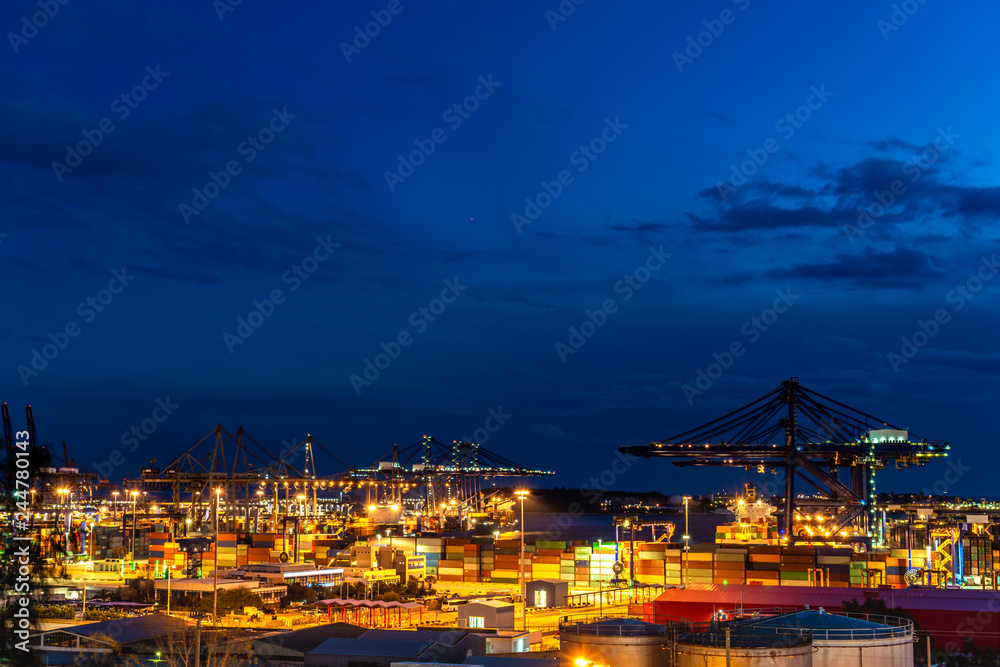 Fototapeta premium Container Cargo freight ship with working crane bridge in shipyard at dusk