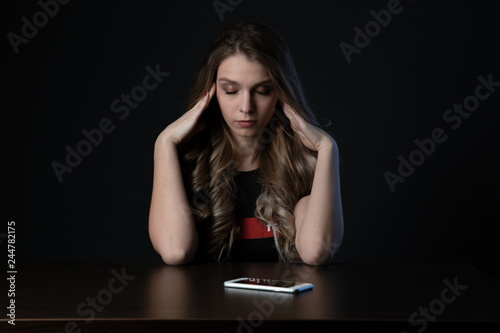 Woman with negative surprised face looking something in smartphone. Sad teenager with mobile phone, scared of threatening, mobile abuse. Front view of a sad teen checkin