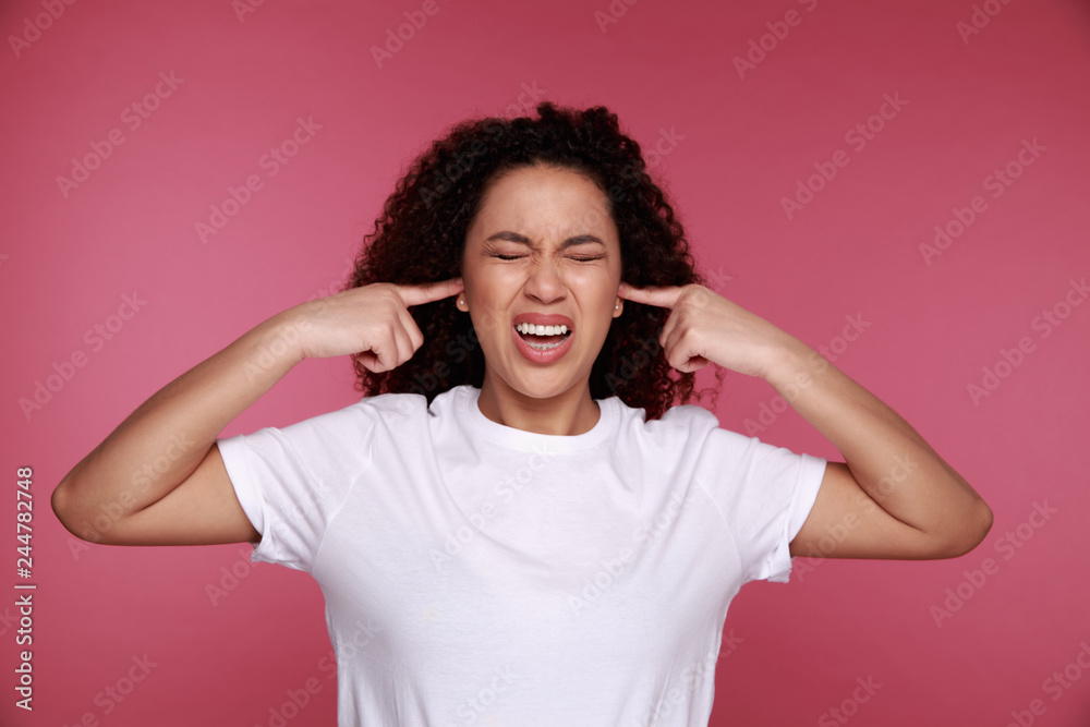 Beautiful young vietnamese woman covering her ears with palms over pink background Beautiful young vietnamese woman covering her ears with palms over pink background