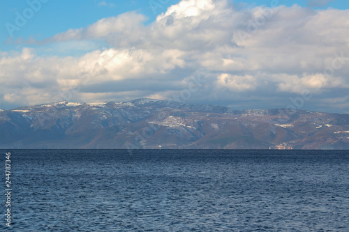 Winter landscape of Ohrid Lake, Galichitsa Mountain and a dramatic cloudy sky. Macedonia.