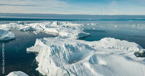 Iceberg aerial drone video - Global warming and climate change concept. Giant icebergs in Disko Bay on greenland in Ilulissat icefjord from melting glacier Sermeq Kujalleq Glacier, Jakobhavns Glacier. photo