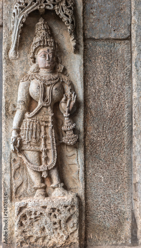 Belur, Karnataka, India - November 2, 2013: Chennakeshava Temple building. Brown stone sculpture of Mohini, avatar of Lord Vishnu on temple wall. 