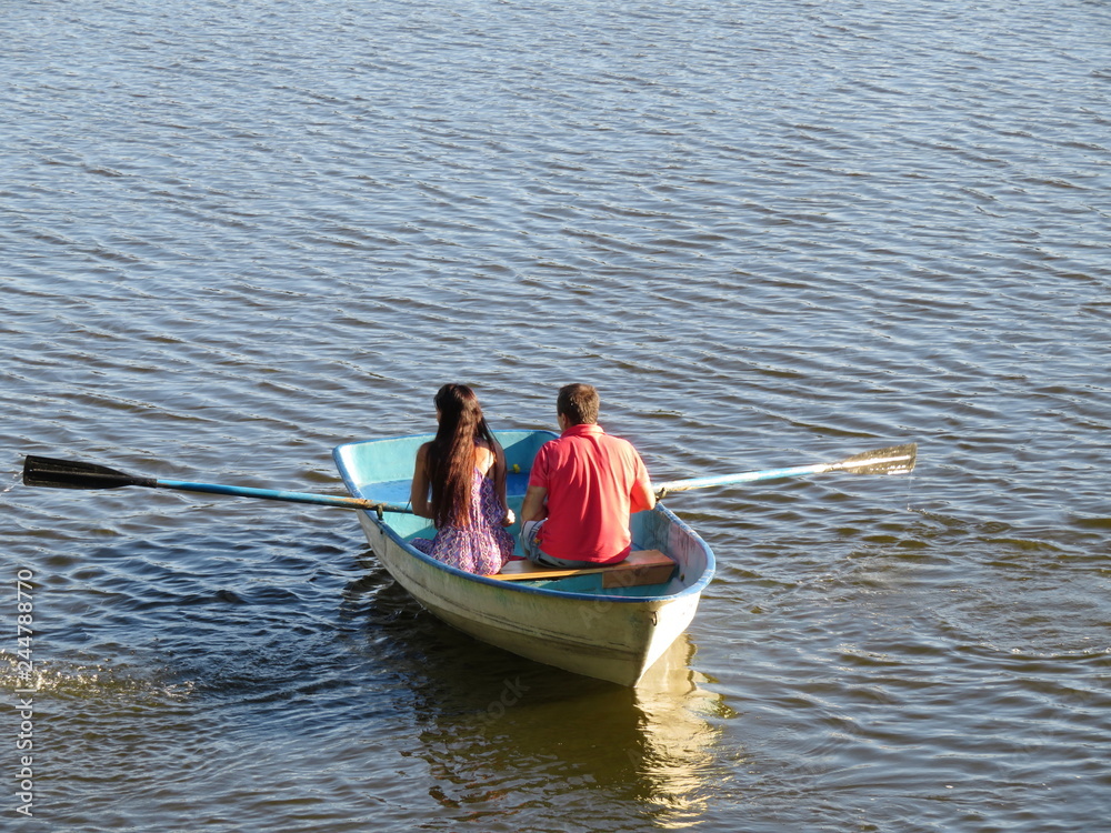 Rowing boat with couple in love. Young man and girl boating on a lake, concept of romantic date, leisure on the water