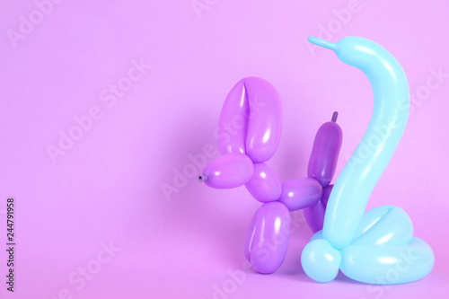 Animal figures made of modelling balloons on color background. Space for text