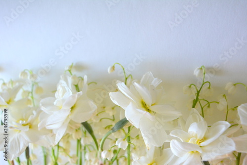 beautiful tender floral composition. Flowers lilies of the valley and daffodils on a white background. spring freshness